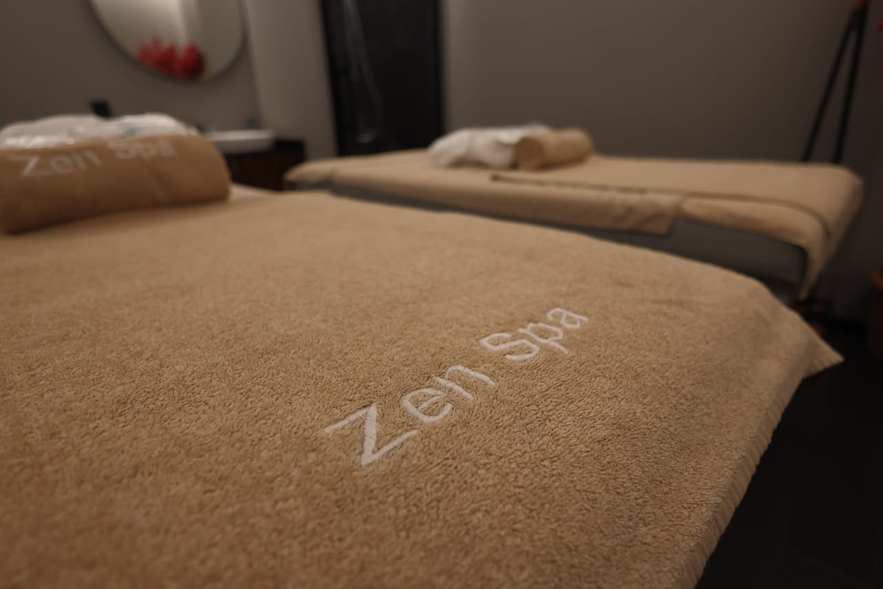 Zen Spa işlemeli havlularla iki masaj yatağı